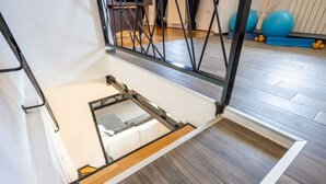 Une pièce dotée d’un plancher en bois, d’un canapé blanc et d’une structure en métal.