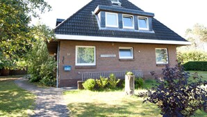 A two-story house with a sloped roof, a small porch, and a brick exterior. - Holiday Home Villa Piep (Nebel)