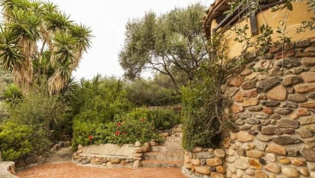 A stone wall with a brick pathway leading to a building. - Ines Comfortable Holiday Residence (Maracalagonis)