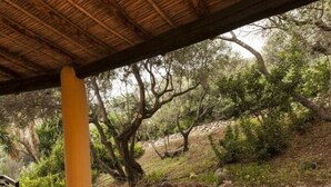 An outdoor patio area with a curved brick bench and a stone wall. - Ines Comfortable Holiday Residence (Maracalagonis)