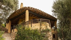 A rustic stone staircase leading to a wooden-roofed building surrounded by greenery. - Ines Comfortable Holiday Residence (Maracalagonis)