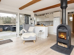 A modern interior with a fireplace, a dining area, and a kitchen. - 4 Star Holiday Home in Fano (Fano)