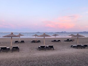 Accommodatie ligt op het strand, ligstoelen, strandlakens