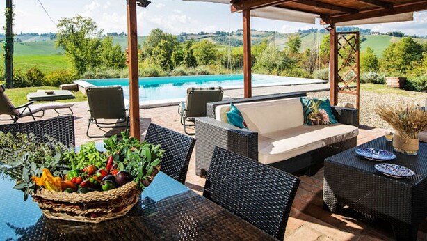A covered outdoor area with a pool, wicker furniture, and a view of the countryside. - Sunny Holiday Home With Swimming Pool (Salsomaggiore Terme)