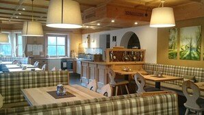 A cozy restaurant with wooden furniture, pendant lighting, and a rustic interior.