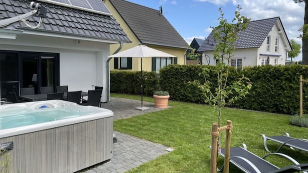 Een woonwijk met een zwembad, terras en zonnepanelen op een huis.