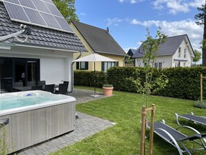 Een woonwijk met een zwembad, terras en zonnepanelen op een huis.