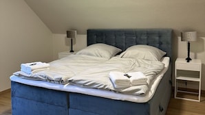 A bedroom with a bed, two bedside tables, and lamps. - Florentine - Marbi (Varel)
