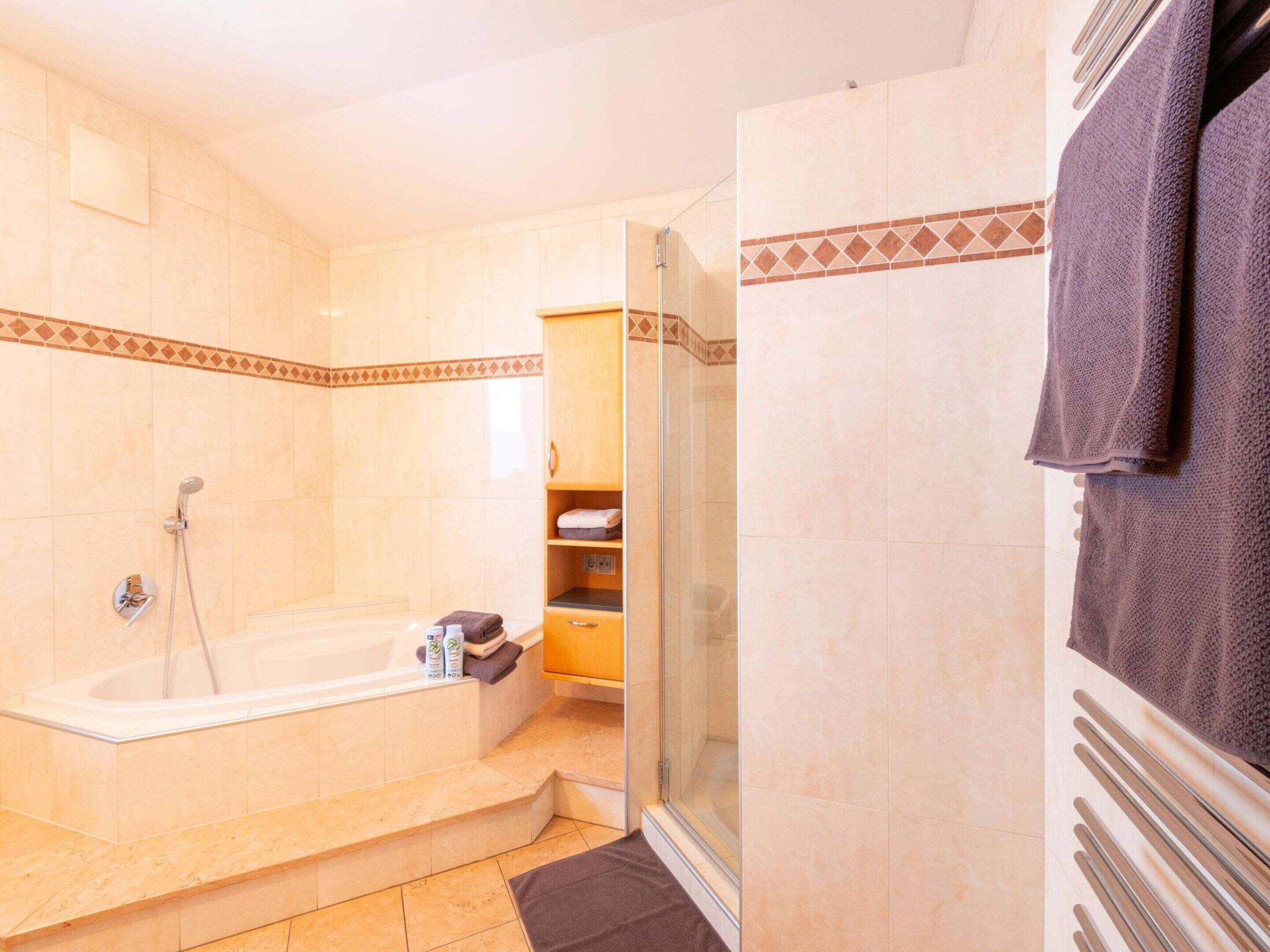 Een badkamer met een bad, douche en douchecabine.