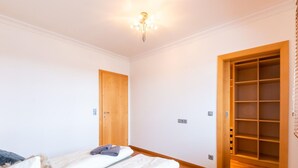 A bedroom with a bed, a wardrobe, and a built-in shelving unit. - Apartment in Niedernsill Near Ski Slopes (Niedernsill)