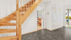 A modern interior with a wooden staircase leading to a living area. - 10 Person Holiday Home in Lindesnes (Lindesnes)