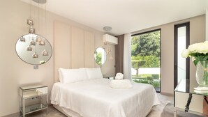 Une chambre à coucher moderne, dotée d’un grand lit, de tables de chevet et offrant une vue sur l’extérieur.