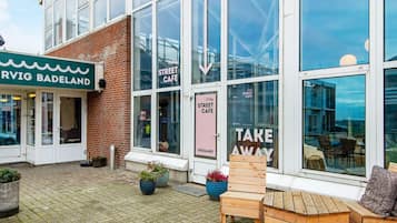 A street cafe with large windows and outdoor seating.