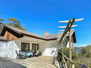 A wooden deck with outdoor furniture, a pergola, and a view of a lake. - 5 Person Holiday Home in Stillingson (Stillingsön)