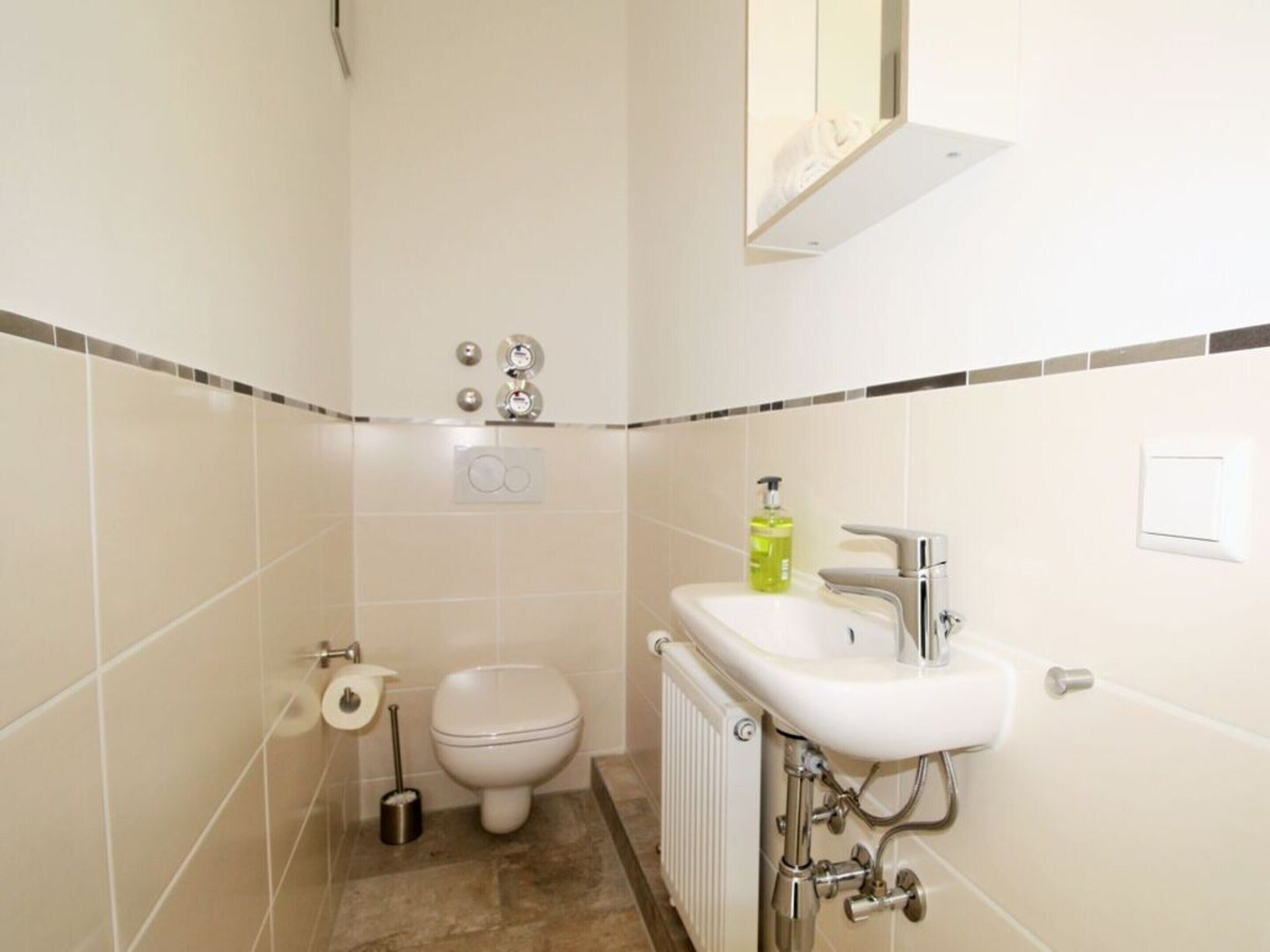 Une salle de bain équipée de toilettes, d’un bidet et d’un lavabo.