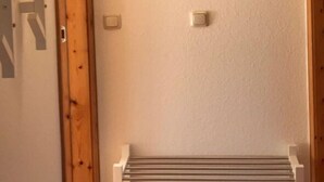 Een gang met houten deuren, een radiator en de letters A, B, C op de muur.
