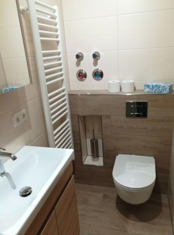 A small bathroom with a white sink, a toilet, and a towel rack. - Nice Apartment in Bodenmais (Bodenmais)