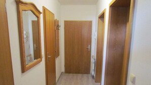 Un couloir avec des portes en bois et un radiateur.