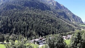 A mountainous landscape with a house surrounded by dense forest. - Saerbecker Berghutte (Heiligenblut)