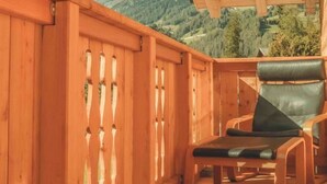 A wooden deck with a view of a mountain range. - Saerbecker Berghutte (Heiligenblut)