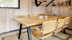 Une salle à manger en bois avec une grande table et quatre chaises.