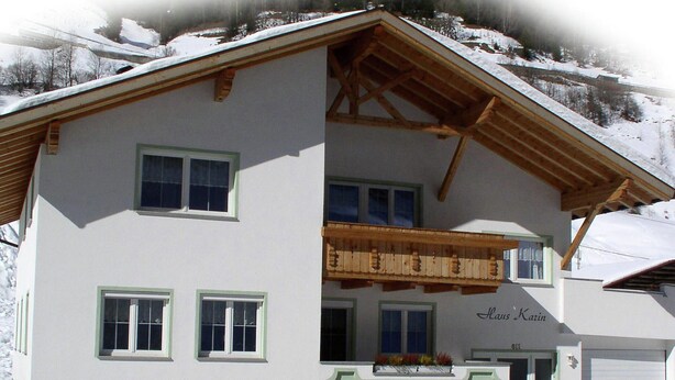 Een gebouw met twee verdiepingen, een balkon, een garage en een bord met de tekst 