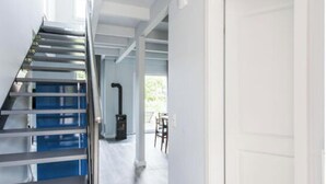 A modern staircase with metal railings and a wooden floor leading to a white door. - Fischer Heiligenhafen 4b (Heiligenhafen)
