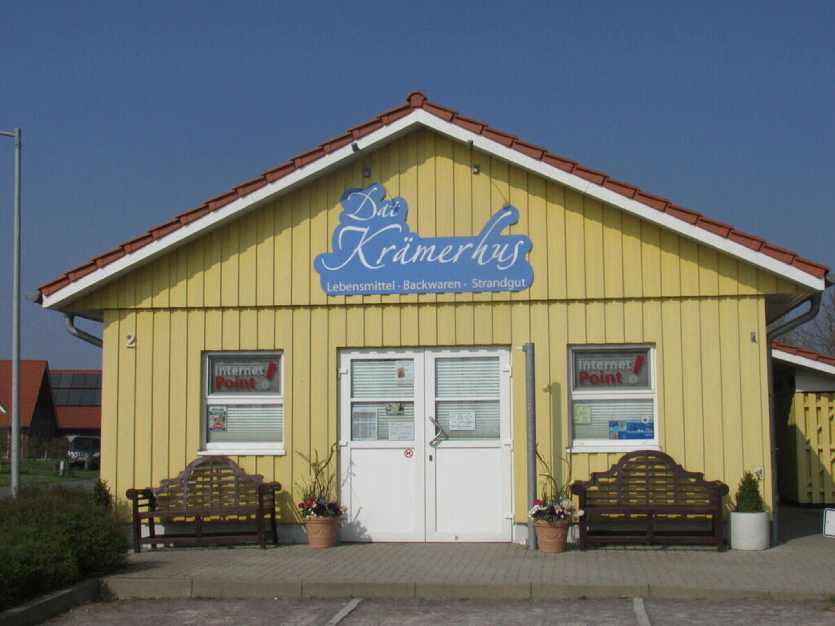 A yellow building with a sign reading "Das Krimmerhus" and "Lebensmittel - Backwaren - Strandgut".