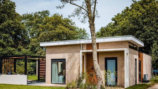 A modern two-story house with a brick facade, large windows, and a covered outdoor seating area. - Spacious Holiday Home in Voorhuizen With Terrace (Voorthuizen)