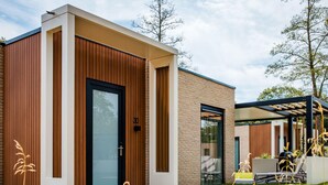Un bâtiment moderne avec une façade en bois, une porte noire et une enseigne portant le numéro « 30 ».