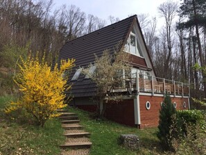 A house with a sloped roof, a wooden deck, and a brick exterior. - Modern Apartment Near Centre (Leinsweiler)