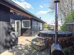 A wooden deck with a hot tub, a covered seating area, and a sauna. - 6 Person Holiday Home in Hojslev (Hojslev)