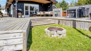 A wooden deck with outdoor seating and a barbecue area. - 6 Person Holiday Home in Hojslev (Hojslev)