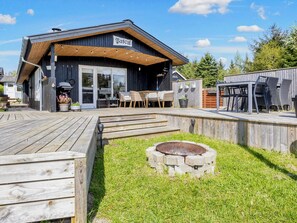 A wooden deck with outdoor seating and a barbecue area. - 6 Person Holiday Home in Hojslev (Hojslev)
