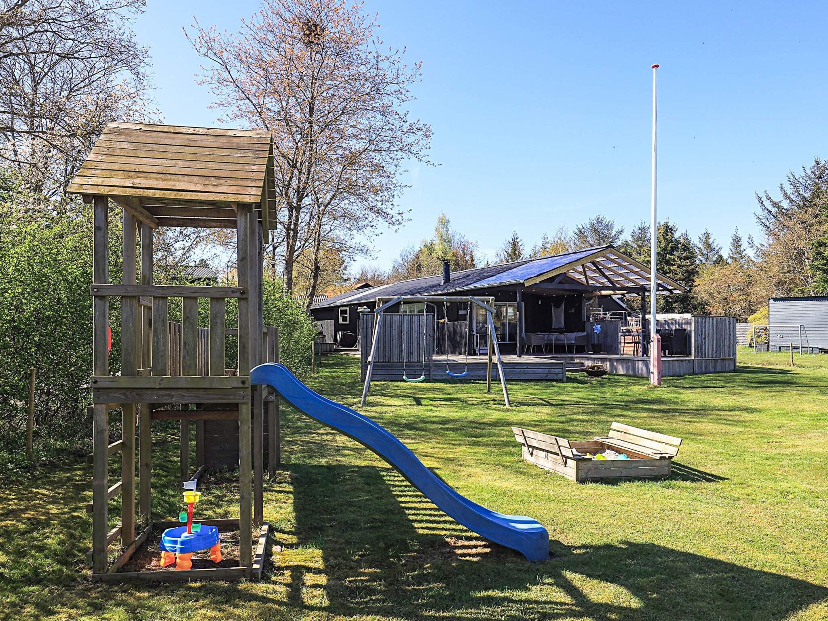 Une aire de jeux avec un toboggan et une structure de jeu en bois.