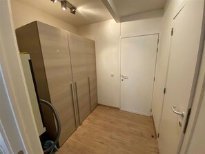 Cozy retreat with a large wardrobe, small door, and convenient light switch.