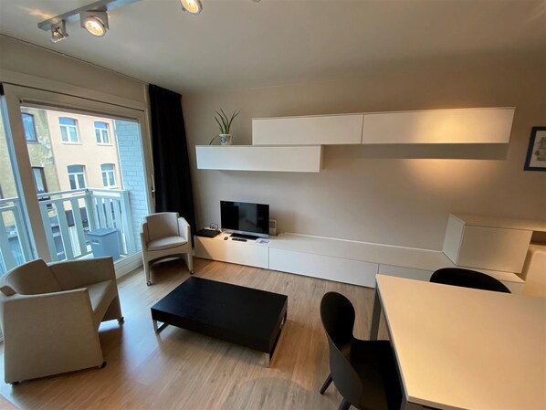 Relax in a spacious living room with a city view, flat-screen TV, and comfortable seating area.