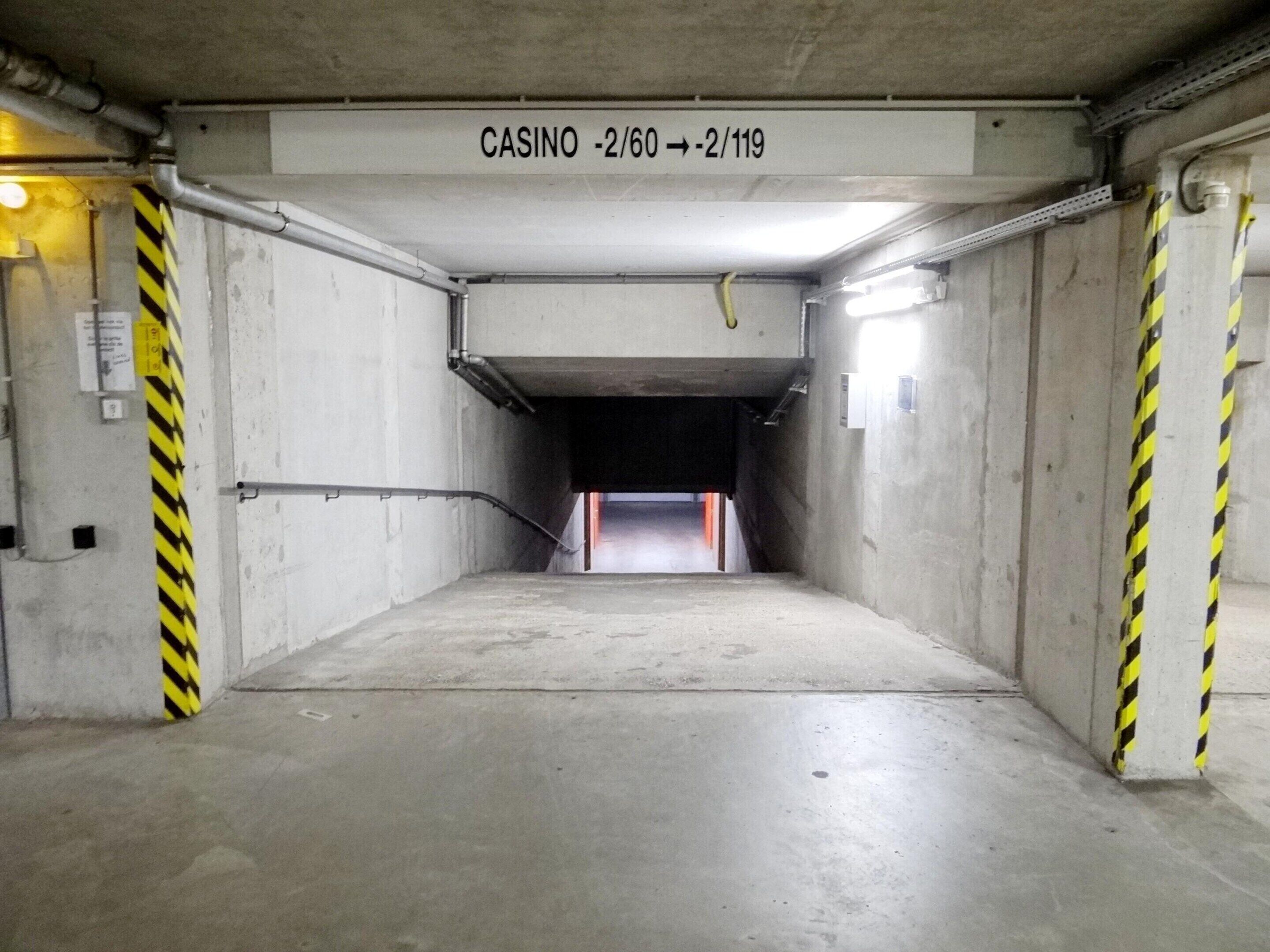 An underground parking garage with a sign indicating 'CASINO -2/60 -> -2/119'.