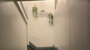 En trappa med en skylt som säger ”Välkommen” och hängande växter.