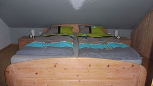 Makuuhuoneessa on puinen sänky, kaksi yöpöytää ja seinämaalaus, jossa kuun kuva heijastuu vedenpintaan.