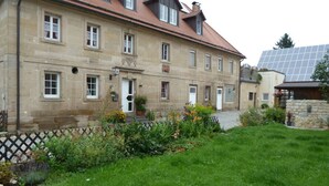 A large stone building with multiple windows and a red-tiled roof. - Nice Apartment in Himmelkron (Himmelkron)