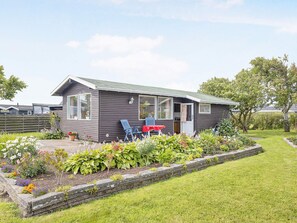 A single-story house with a front porch, a small garden, and a lawn. - 5 Person Holiday Home in Saeby (Sæby)