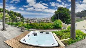 A hot tub on a wooden deck with a view of a cityscape and hills in the background. - Quinta Martin Modern Retreat (Funchal)