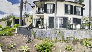 A two-story house with a balcony, surrounded by palm trees and a garden. - Quinta Martin Modern Retreat (Funchal)