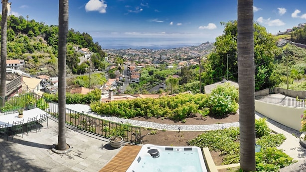 A rooftop terrace with a hot tub, palm trees, and a view of a town. - Quinta Martin Modern Retreat (Funchal)