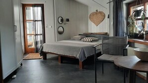 A modern bedroom with a bed, bedside table, and a heart-shaped wall decoration.