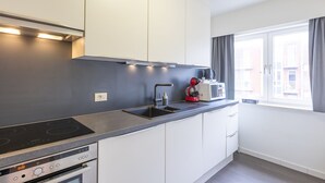 Eine moderne Küche mit Einbauherd, Mikrowelle und Kaffeemaschine.