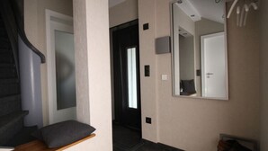 A hallway with a wooden bench, a mirror, and a shoe rack. - Holiday Home Naturally Good (Voehl)