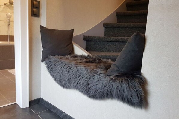 A staircase with a fur-lined wall and two dark pillows. - Holiday Home Naturally Good (Voehl)