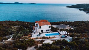 A coastal property with a swimming pool, a covered patio, and a view of the sea. - Brdar Comfortable Holiday Residence (Marina)